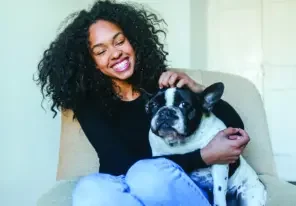 a woman happily petting her dog