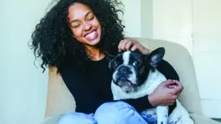 a woman happily petting her dog