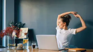 a woman stretching at her desk