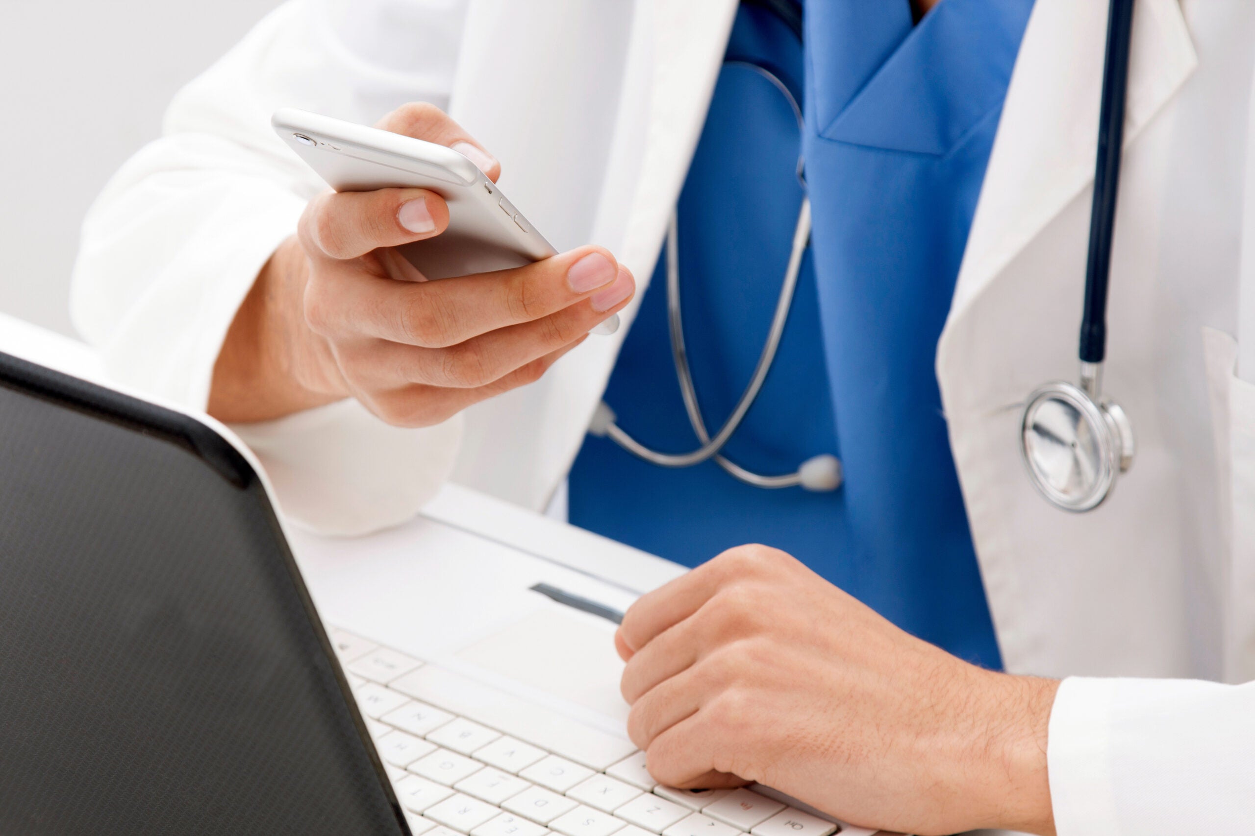 doctor with mobile phone in hands in office