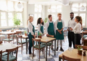 a group of restaurant workers in a stand up meeting