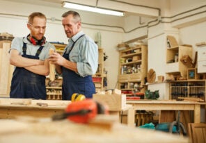 a carpenter showing their child an aspect of their business