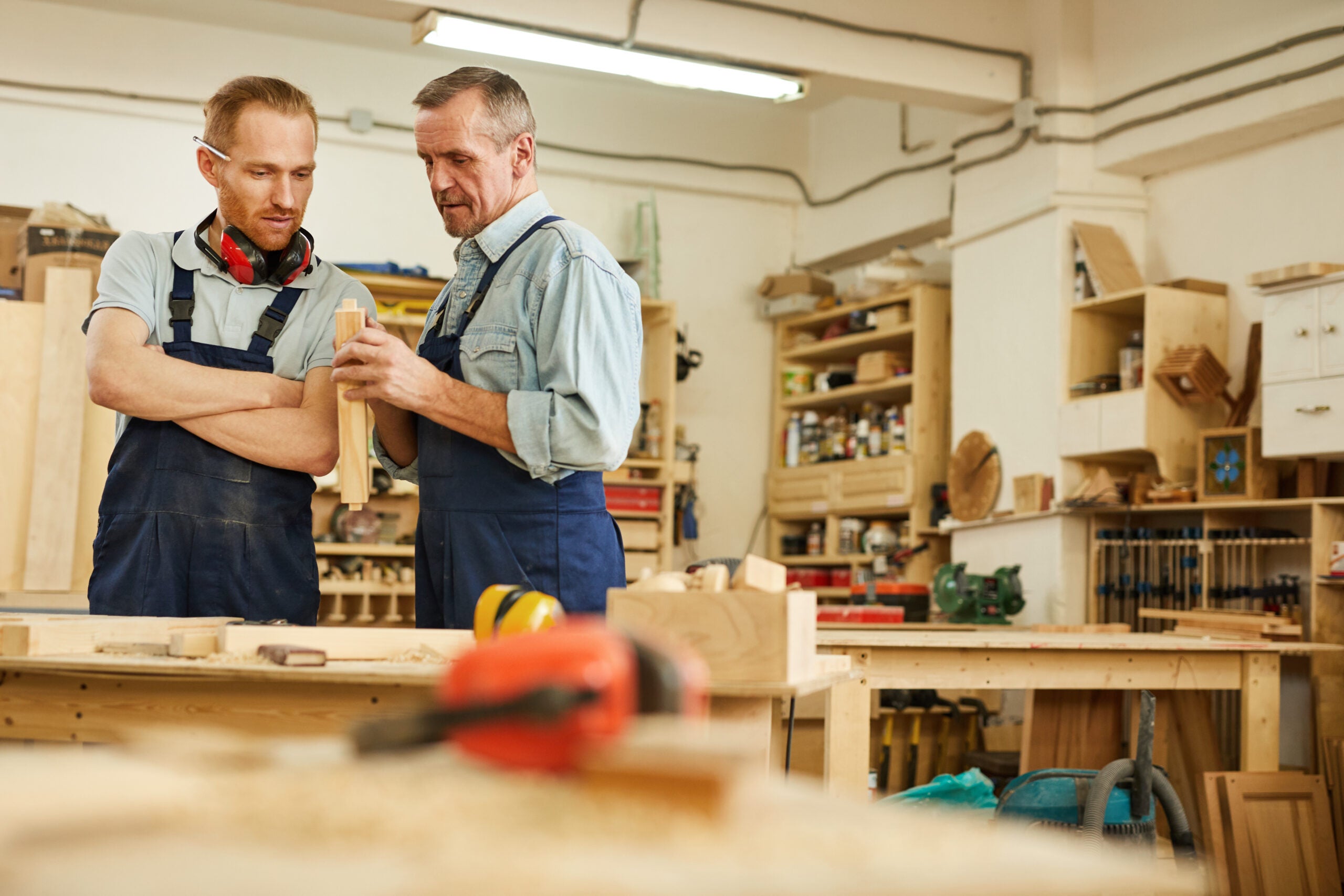 a carpenter showing their child an aspect of their business