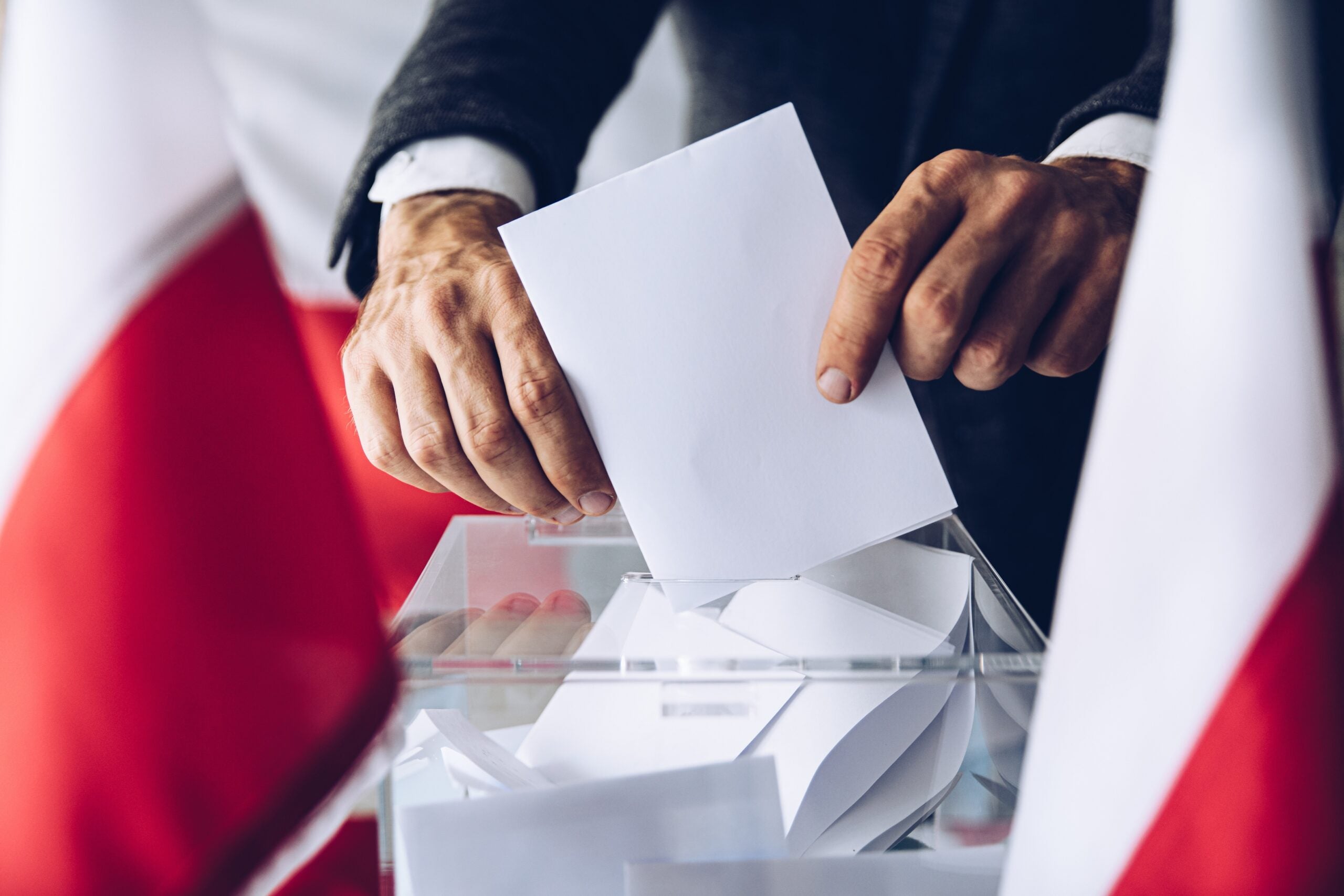 Man putting his vote do ballot box. Political elections in Poland