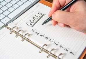 Close-up of a businessman's hand writing goals and list in the diary