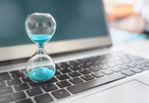 Hourglass on laptop computer concept for time management and countdown to deadline