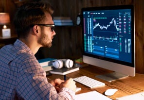 Serious business man trader analyst looking at computer monitor, investor broker analyzing indexes, financial chart trading online investment data on cryptocurrency stock market graph on pc screen.