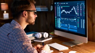 Serious business man trader analyst looking at computer monitor, investor broker analyzing indexes, financial chart trading online investment data on cryptocurrency stock market graph on pc screen.