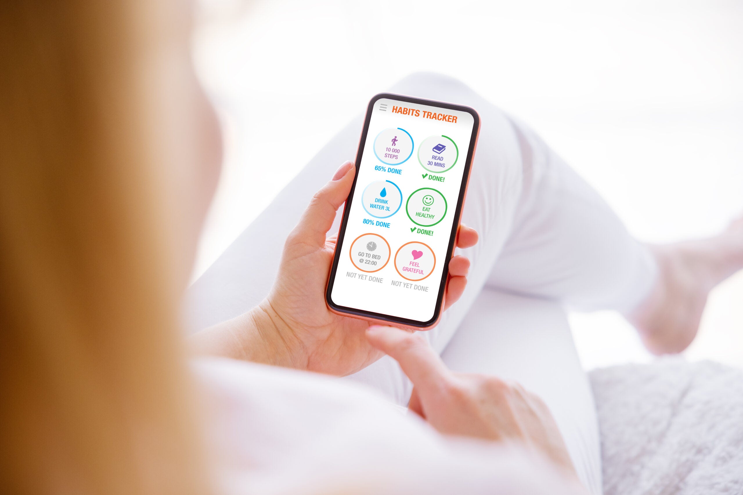 Woman using habits tracker app on mobile phone