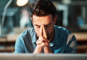 a business owner in distress with their hands in front of their face