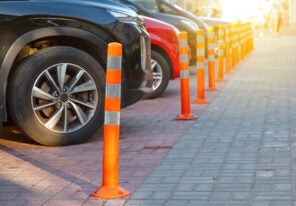 cars lined up and parked behind orange cones