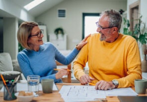 Happy senior couple enjoying their time at home and examining housing plans while relocating into a new house. Elderly couple moving into a new house. Investing in the new property, mortgage.