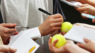 an athlete signing autographs