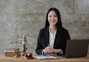 a law firm business owner smiling proudly behind a desk