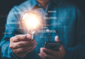 businessman holding a lit lightbulb