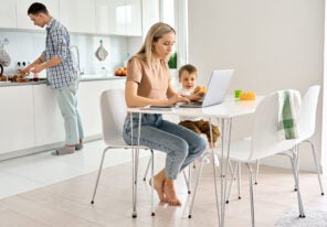 a mother working from home with her child beside her