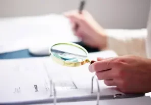 an auditor closely inspecting an invoice