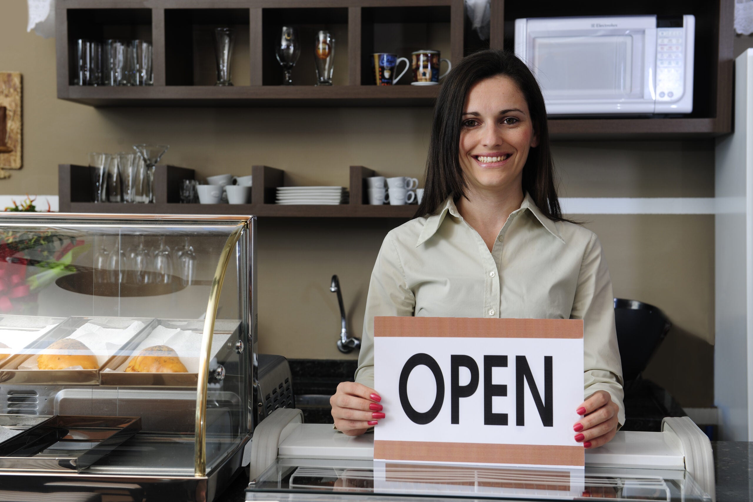 Happy and proud owner Of A Caf Showing Open Sign