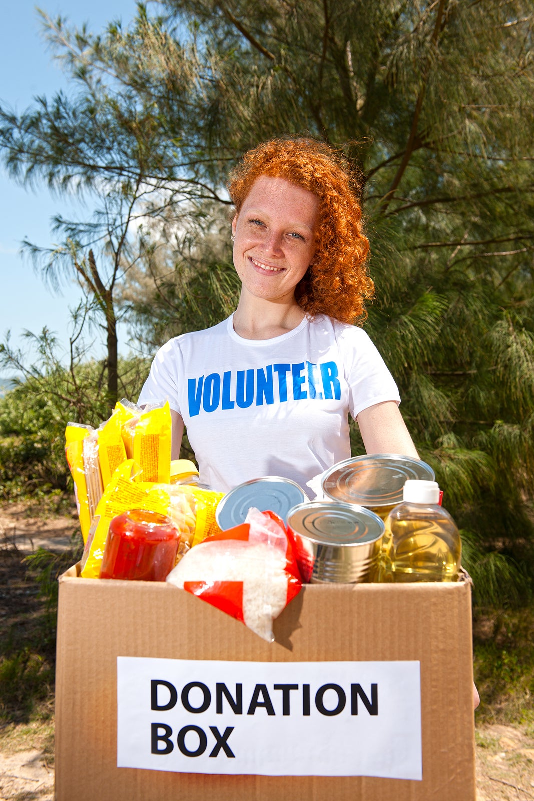 happy volunteer carrying food donation box