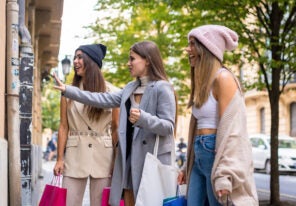 a group of women admiring a window display for a black friday sales event