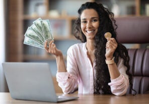 a crypto trader holding cash and a crypto coin