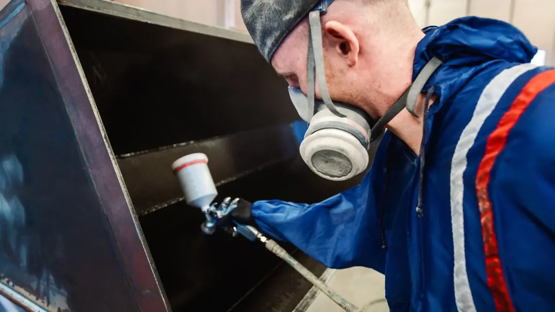 man applying metal treatment to machinery