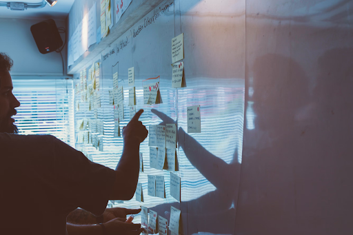 Person pointing to papers on white board